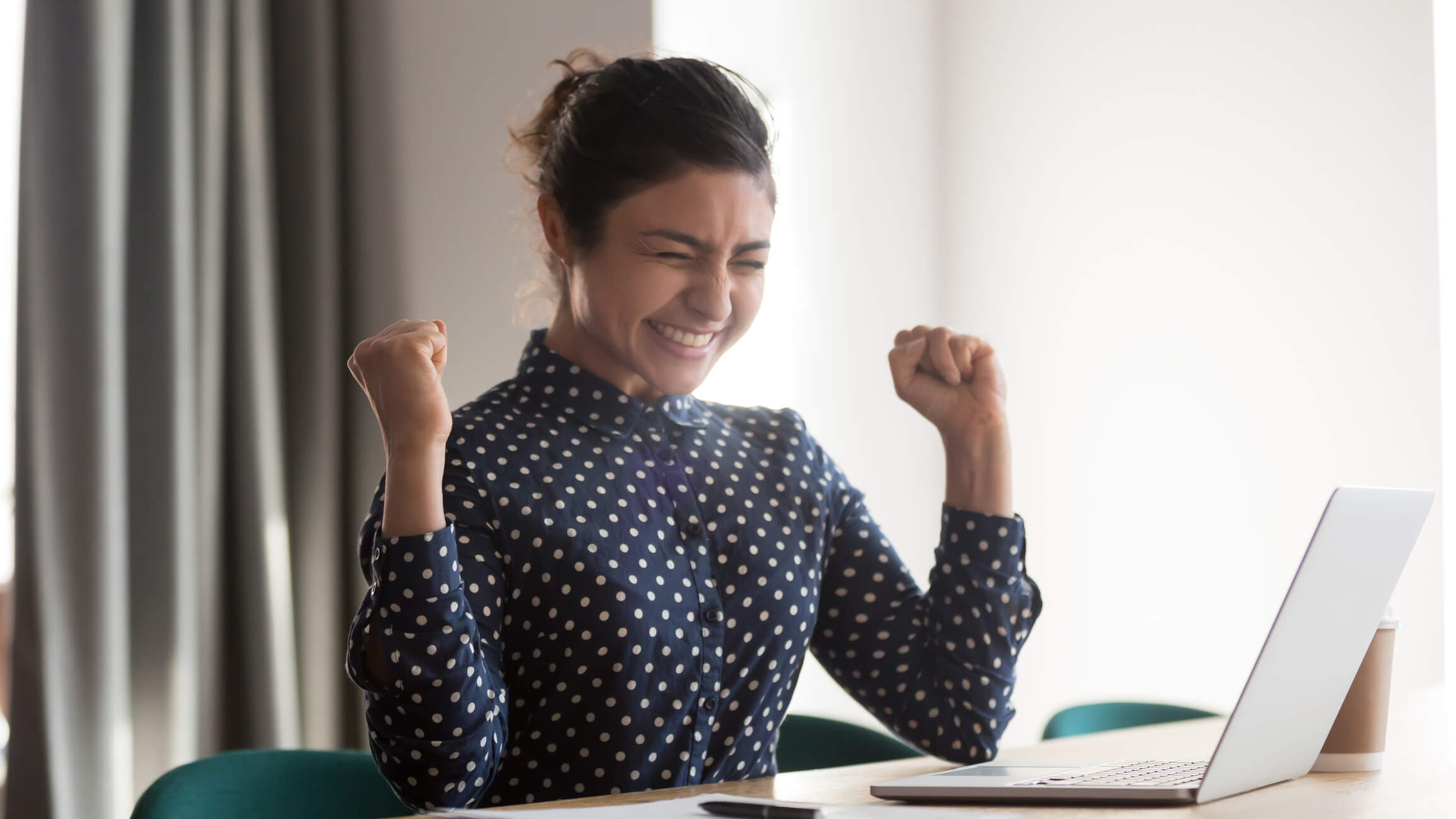 Imagem de uma mulher comemorando um feedback positivo recebido.